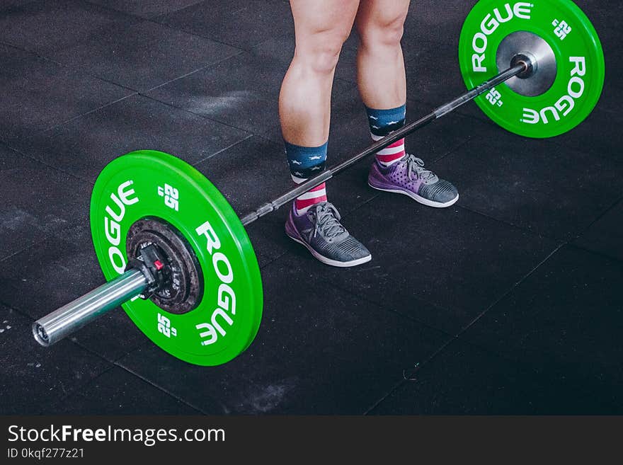 Person Standing in Front of Green and Gray Barbell