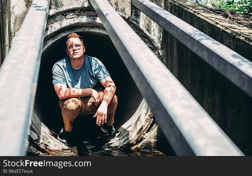 Man Sitting on Manhole