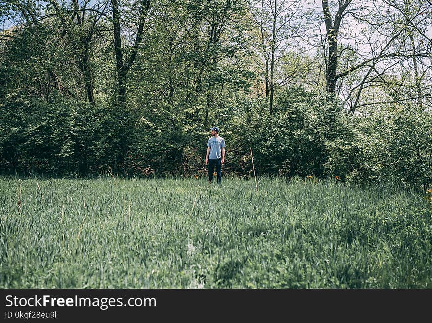 Photography of a Man Standing on Grass Field