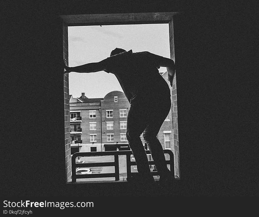 Grayscale Photo of Person Near Building