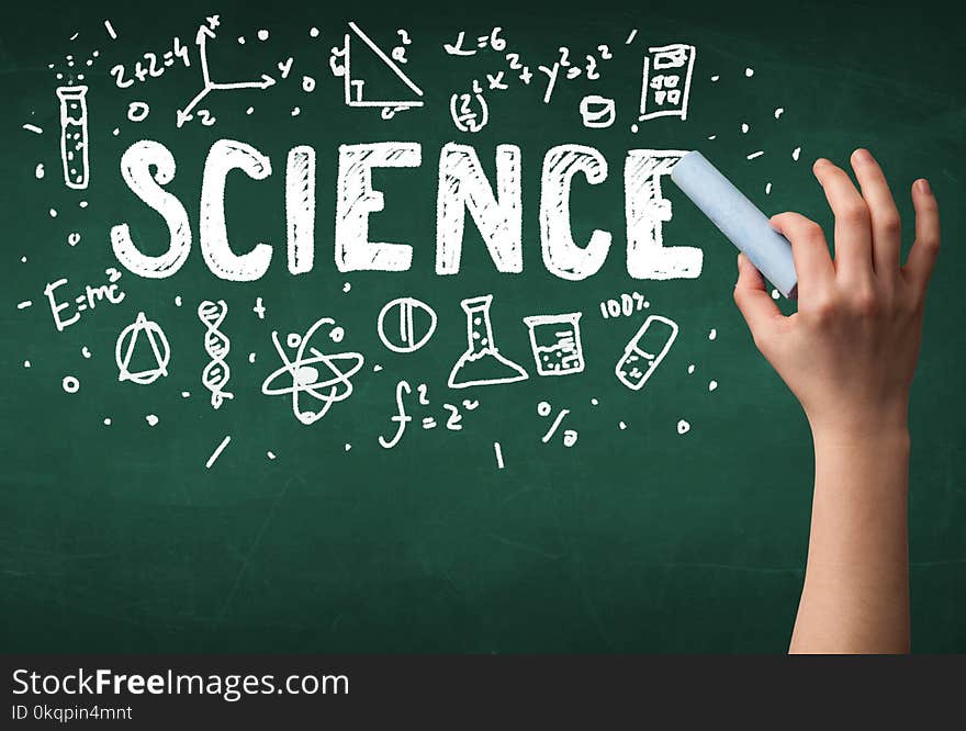 A teacher writing science, drawing chemistry elements on clean green chalkboard by hand. A teacher writing science, drawing chemistry elements on clean green chalkboard by hand