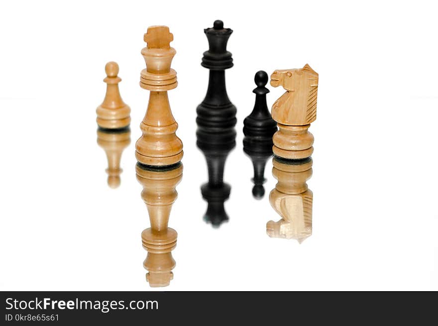 Photo of Black and Beige Wooden Chess Pieces With White Background