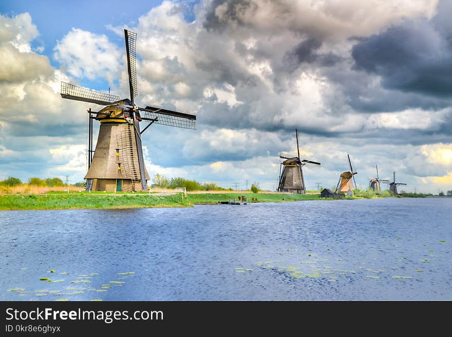 Brown and Black Windmill Beside Body of Water