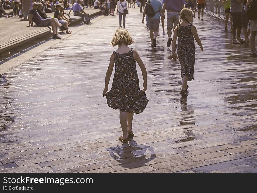 Grayscale Photo of Two Woman Walks on Bricks Pavement Front of People at Daytime