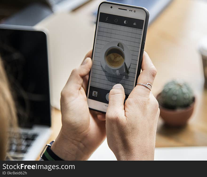 Person Holding White Android Smartphone With Black Rear Case