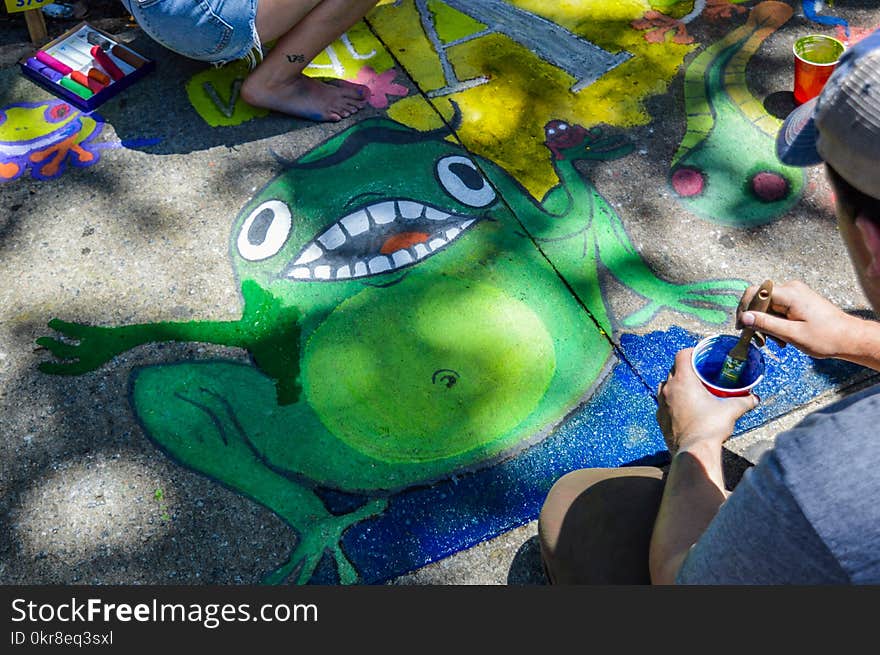 Man Painting Green Frog On Ground