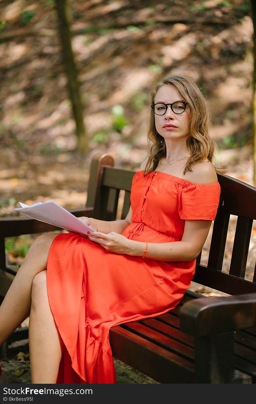 Woman Sitting On Brown Wooden Bench