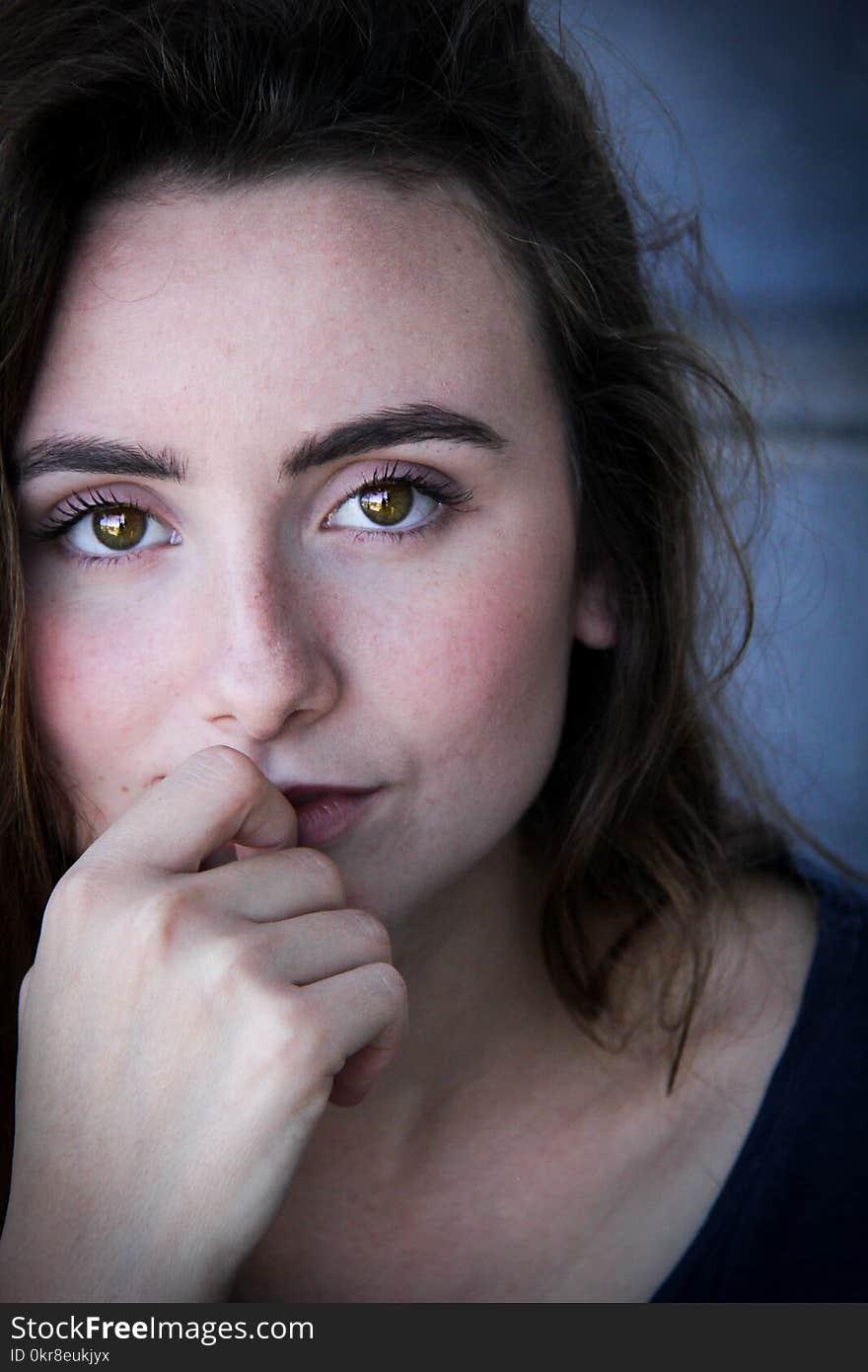 Closeup Photo of Woman in Black Top With Her Index Finger on Top of Her Lower Lip