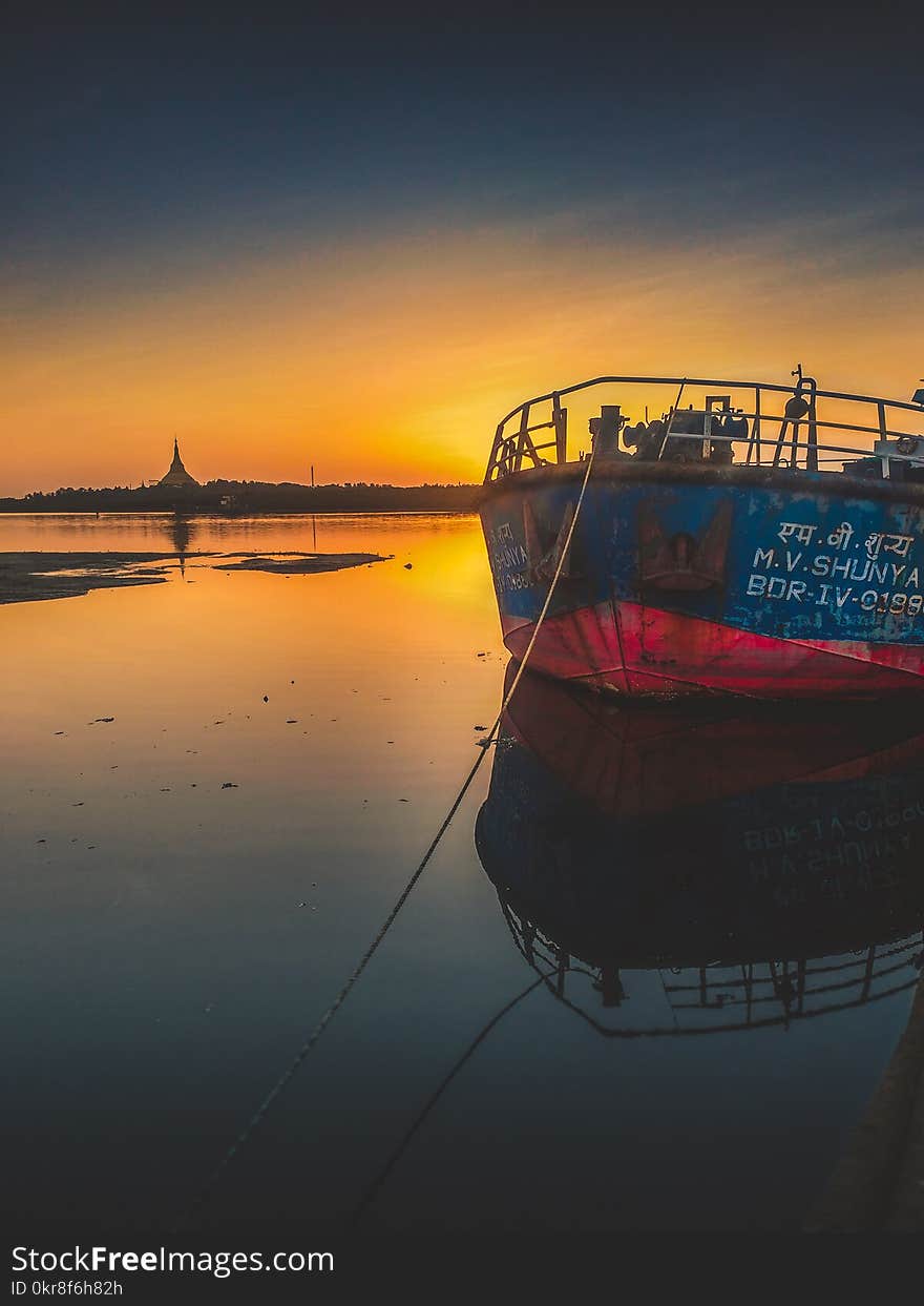 Blue and Red Ship during Golden Hour