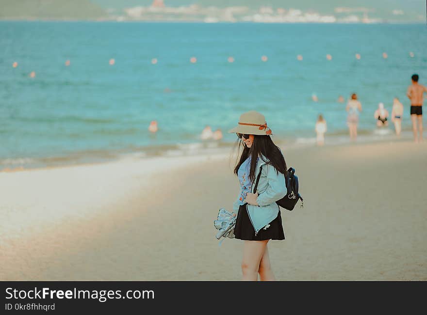 Girl in Cyan Jacket Walking on Beach