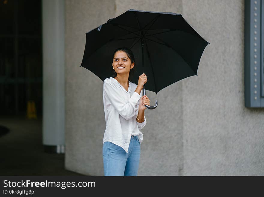 Woman in White Button-up Long-sleeved Shirt Holding Black Umbrella