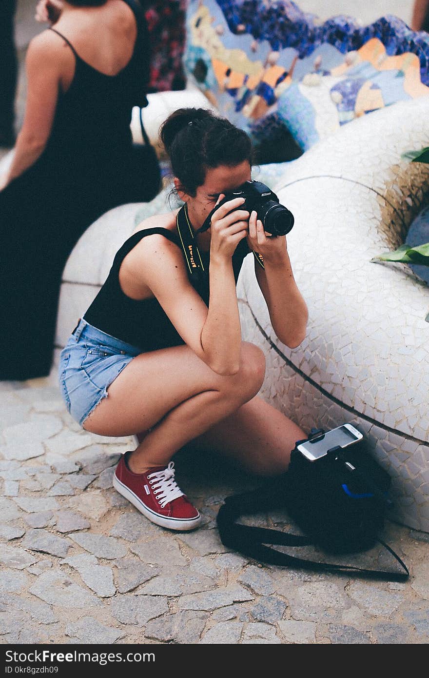 Woman in Black Tank Top Holding Dslr Camera