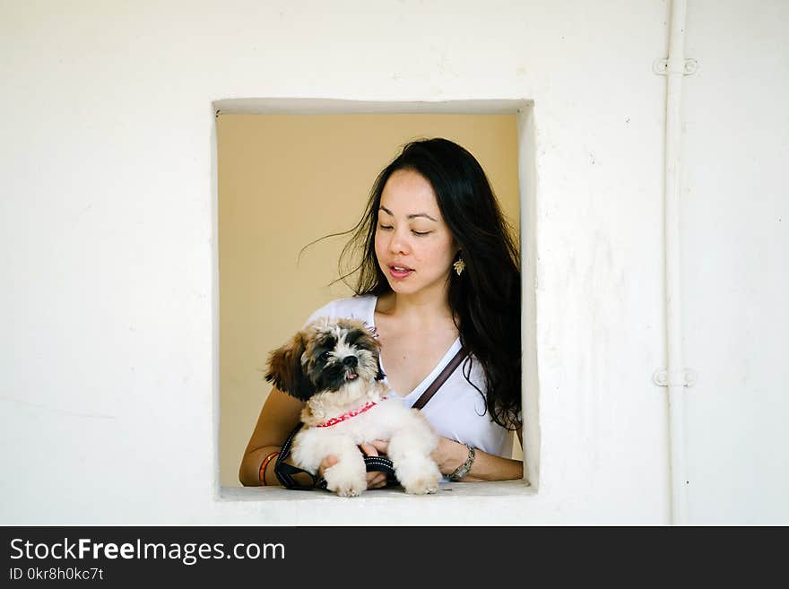 Woman Wearing White Shirt Holding Puppy