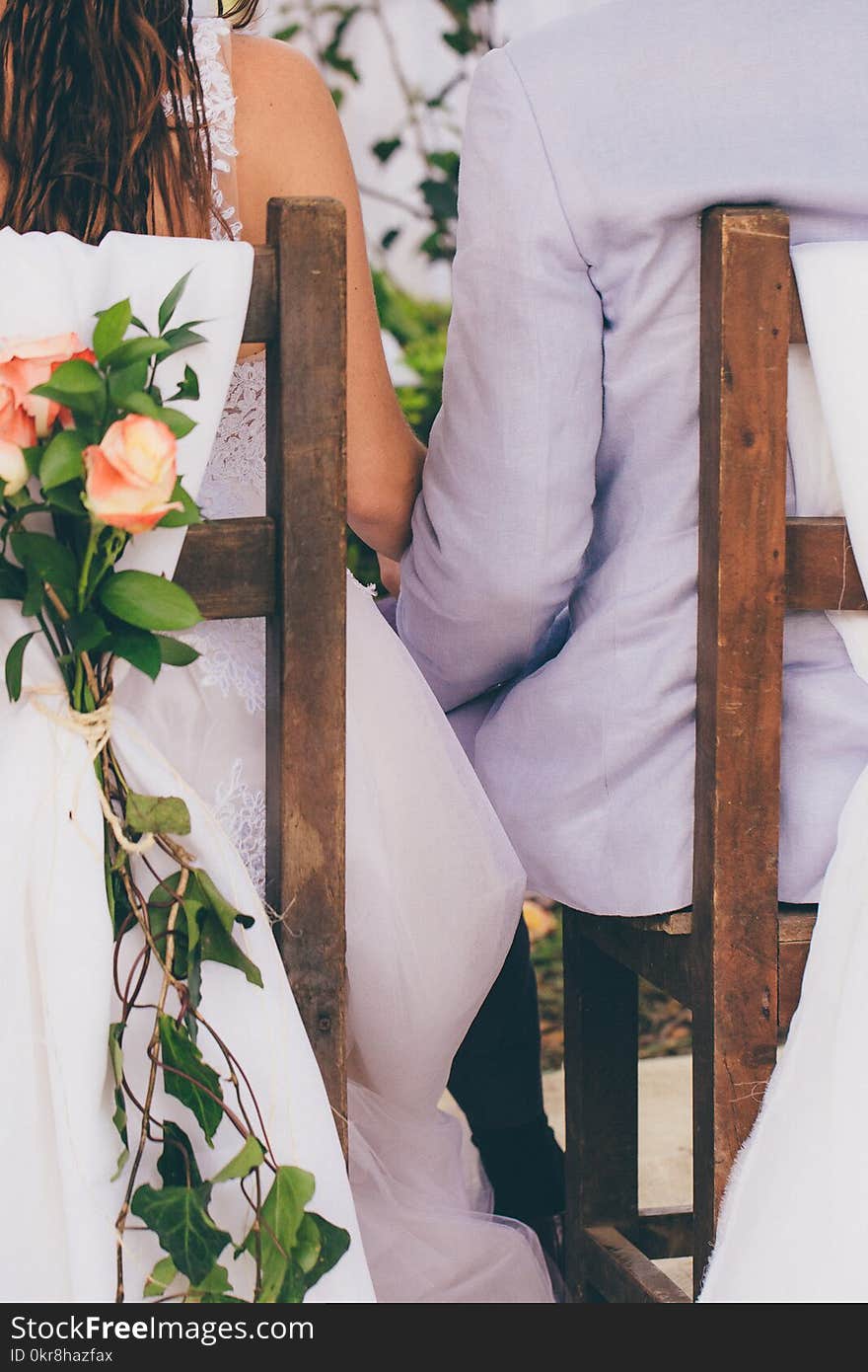 Photo of Person Woman and Man Sitting on Chair and Holding Hands