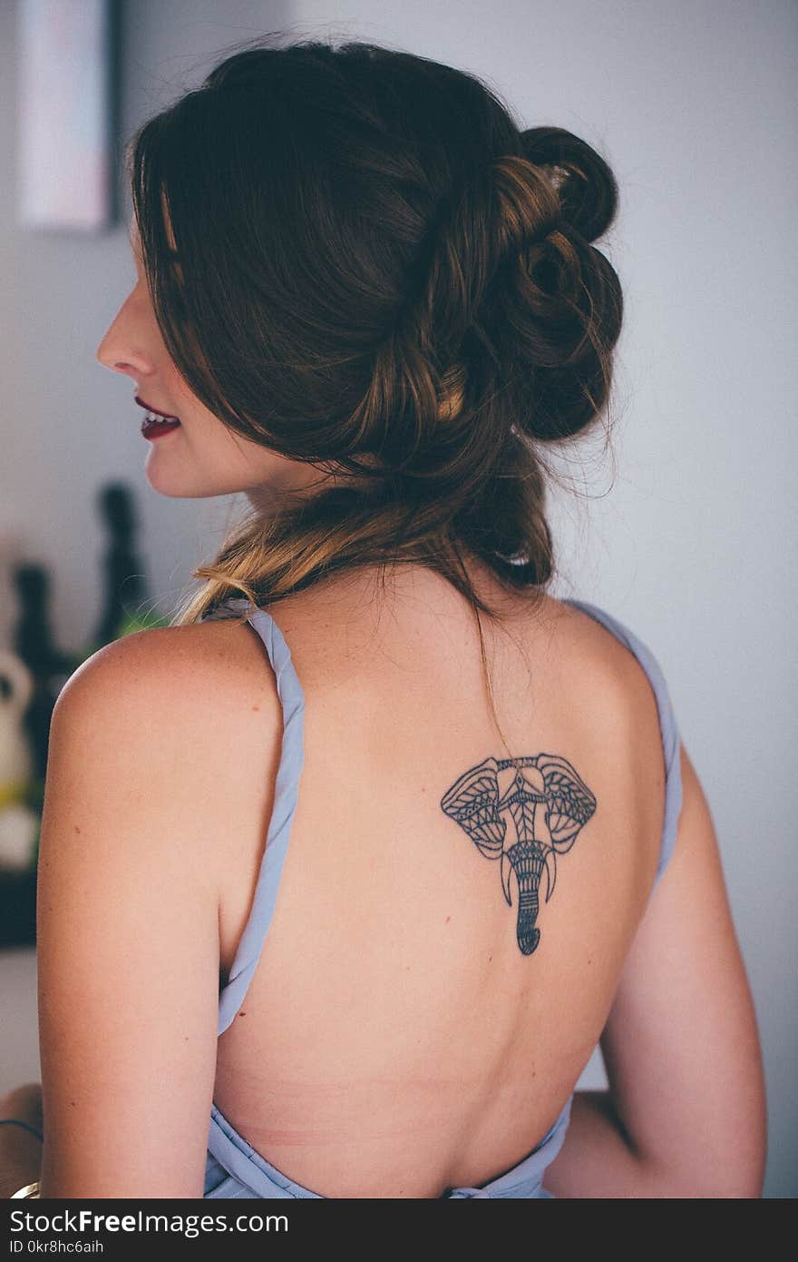 Woman With Black Elephant Tattoo in Back