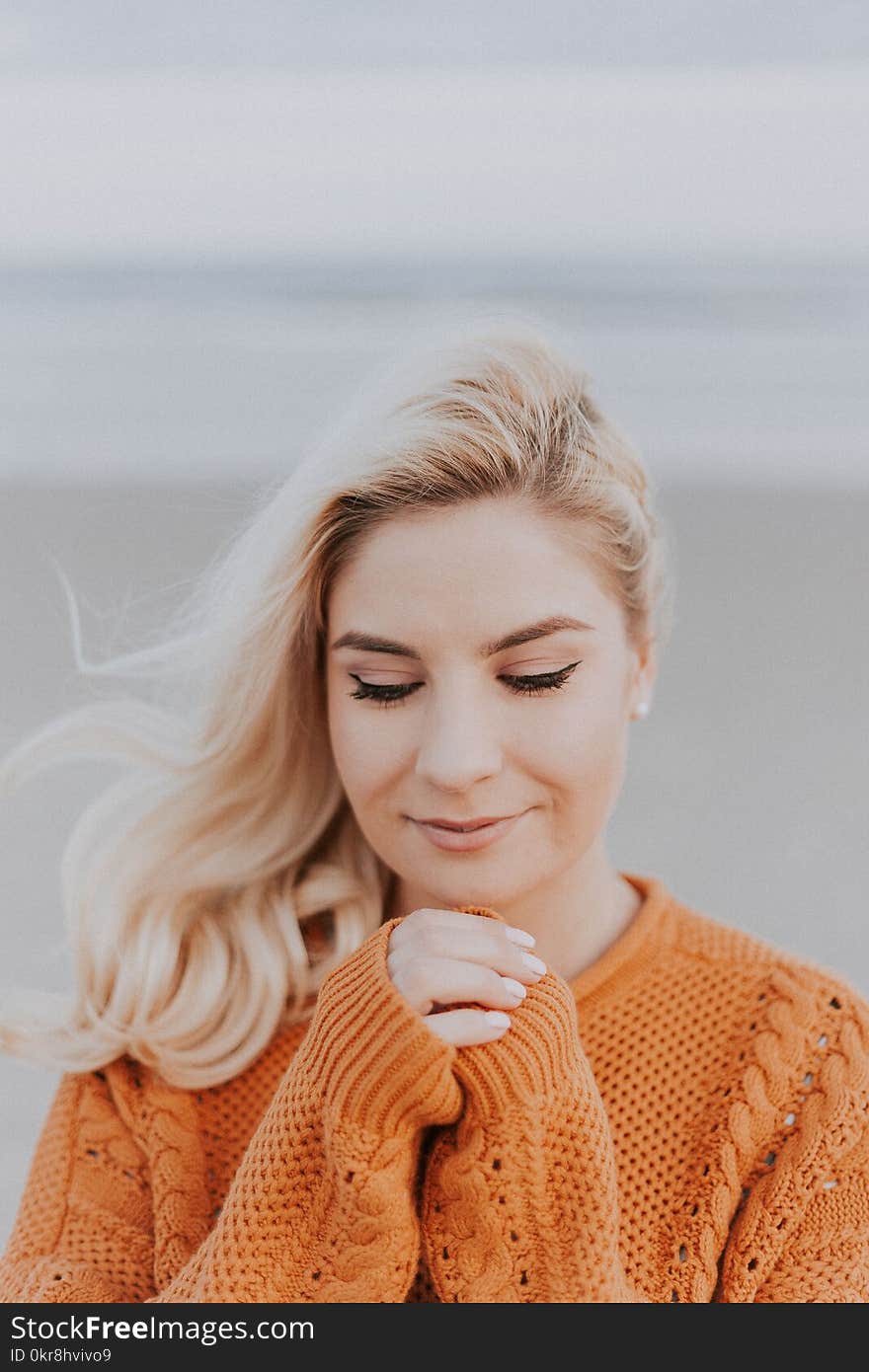 Blonde Haired Woman in Orange Knitted Long-sleeved Top