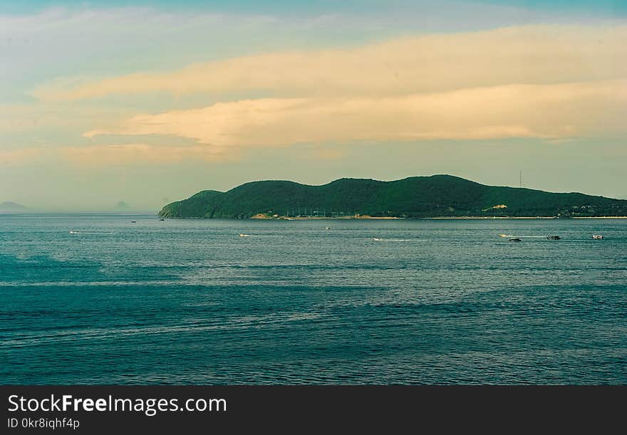 Body of Water With Background of Mountain during Golden Hour