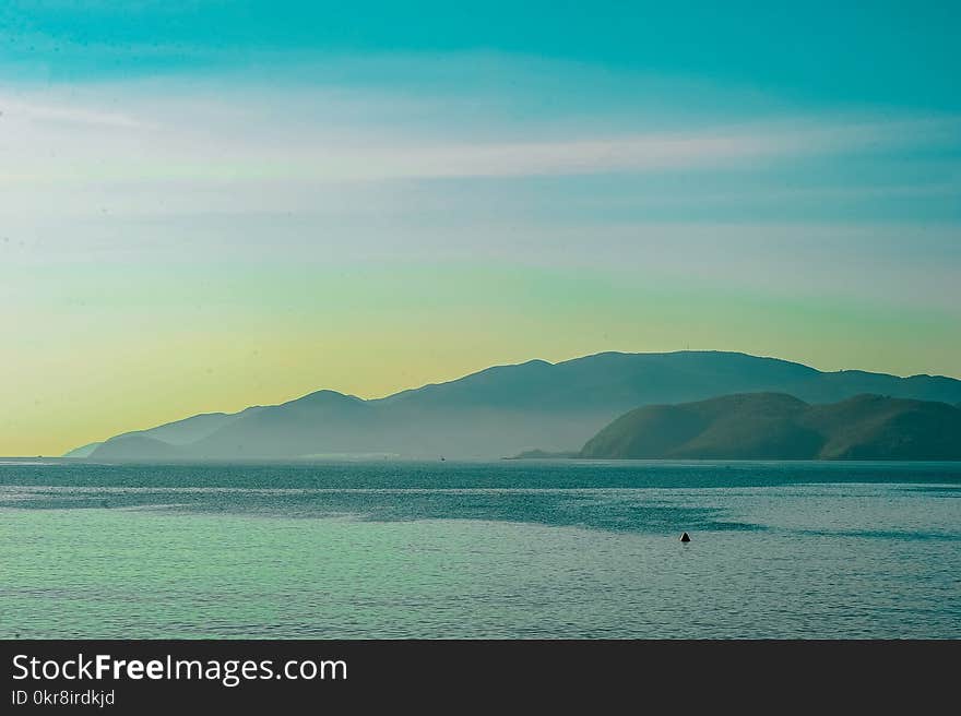 Body of Water Overlooking Islands Under Blue Daytime Sky