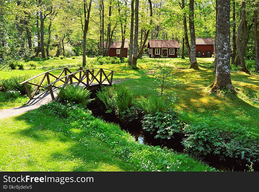 Brown Wooden House Near the Creek With a Bridge