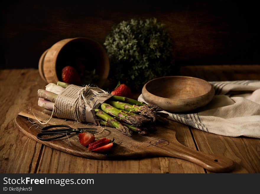 Asparagus on Wooden Board Beside Wooden Bowl