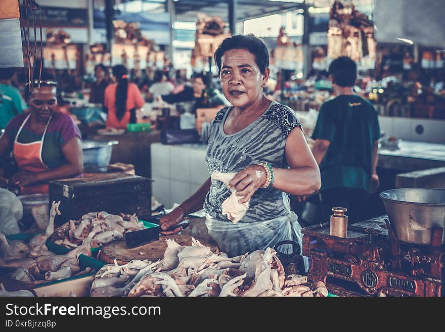 Woman in Gray Shirt Holding a Chicken Piece