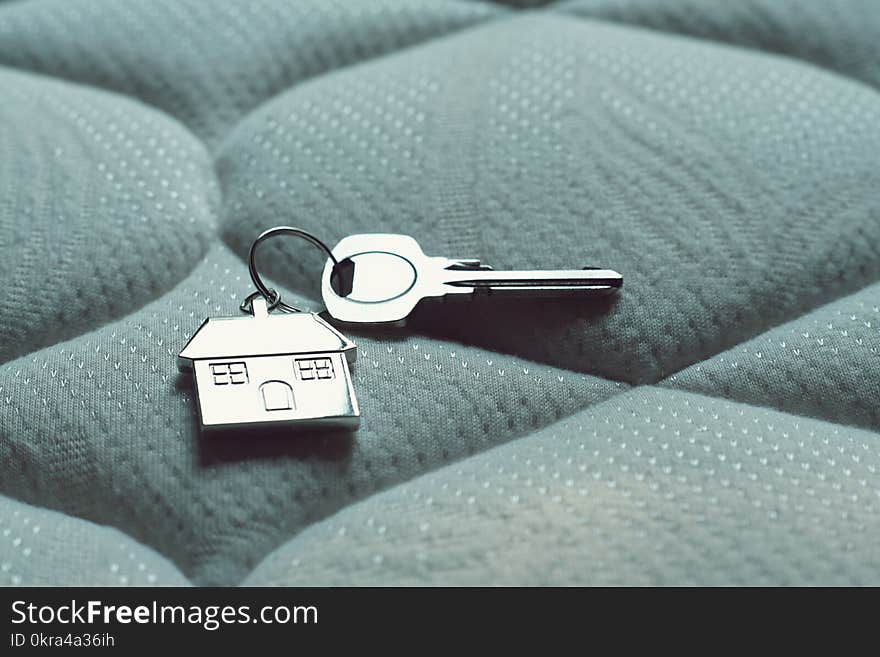 Home Key With House Keychain On Bed, Property Concept