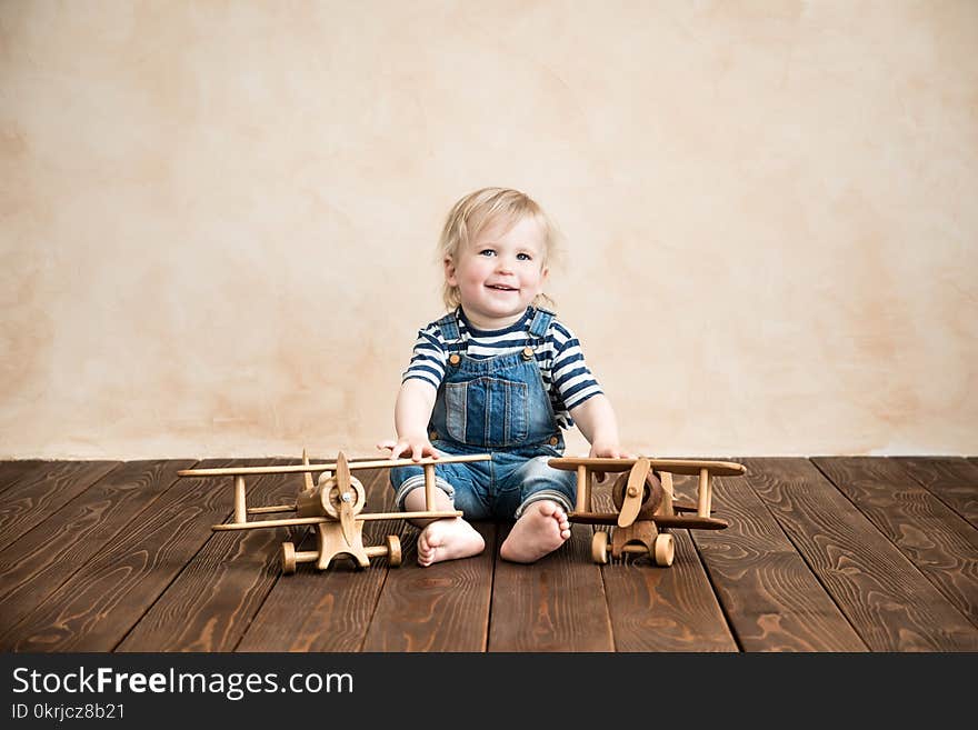 Happy child playing at home. Baby boy with toy airplane. Summer vacation and travel, dream and imagination concept. Happy child playing at home. Baby boy with toy airplane. Summer vacation and travel, dream and imagination concept