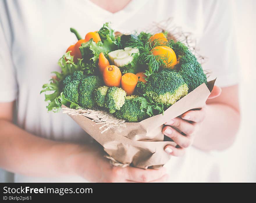 Girl is holding a bouquet of fresh vegetables. Toned image