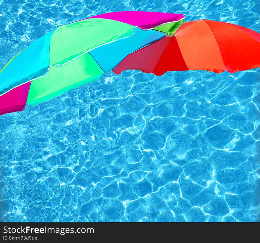 Bright color parasols over turquoise blue pool