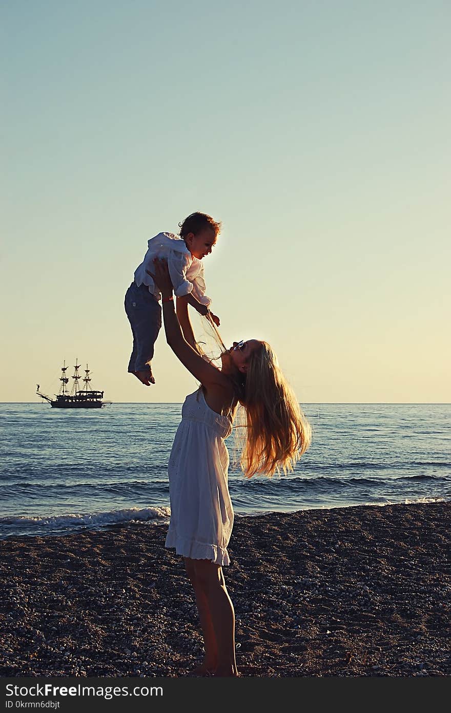 Mother with child on the beach in Side, Turkey, against the background of the sea old ship. Mother with child on the beach in Side, Turkey, against the background of the sea old ship