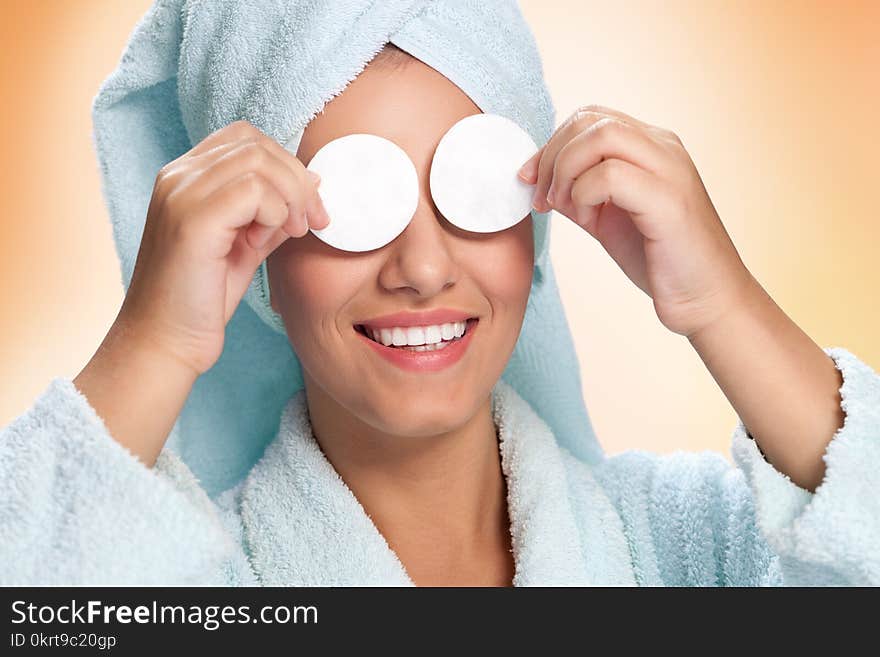 Woman holding cotton pads on her eyes