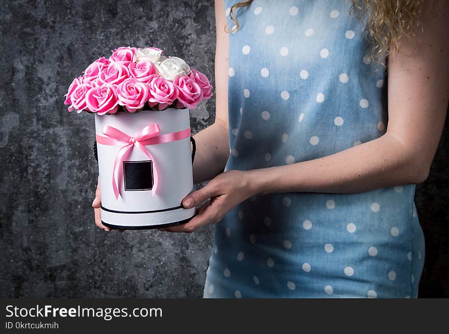 A Girl In A Blue Dress Is Holding A Bouquet Of Red And White, Pink And White Roses In A Hat Box. Dark Gray Background.