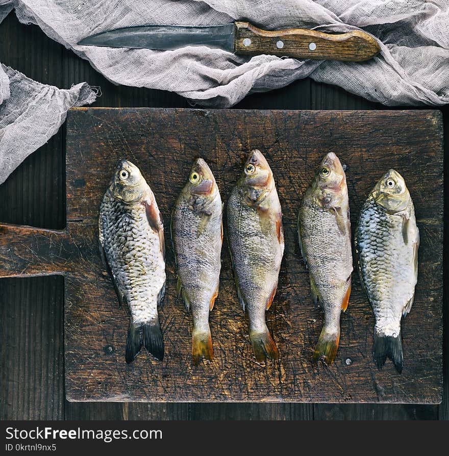 River fish crucian and perch on a brown wooden board, top view