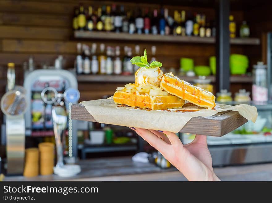 Close up hand holds Belgian waffles on tray