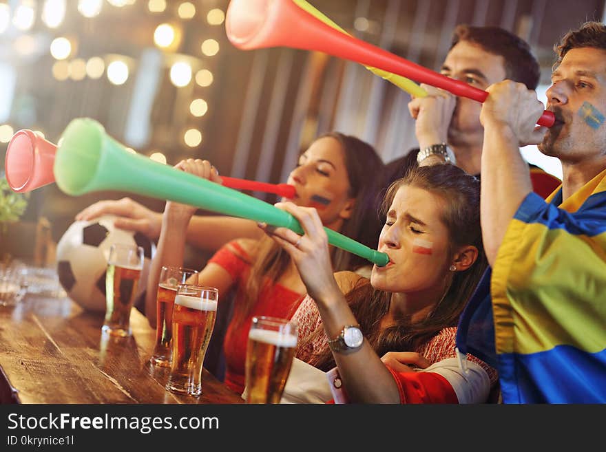 Group of friends watching soccer in pub