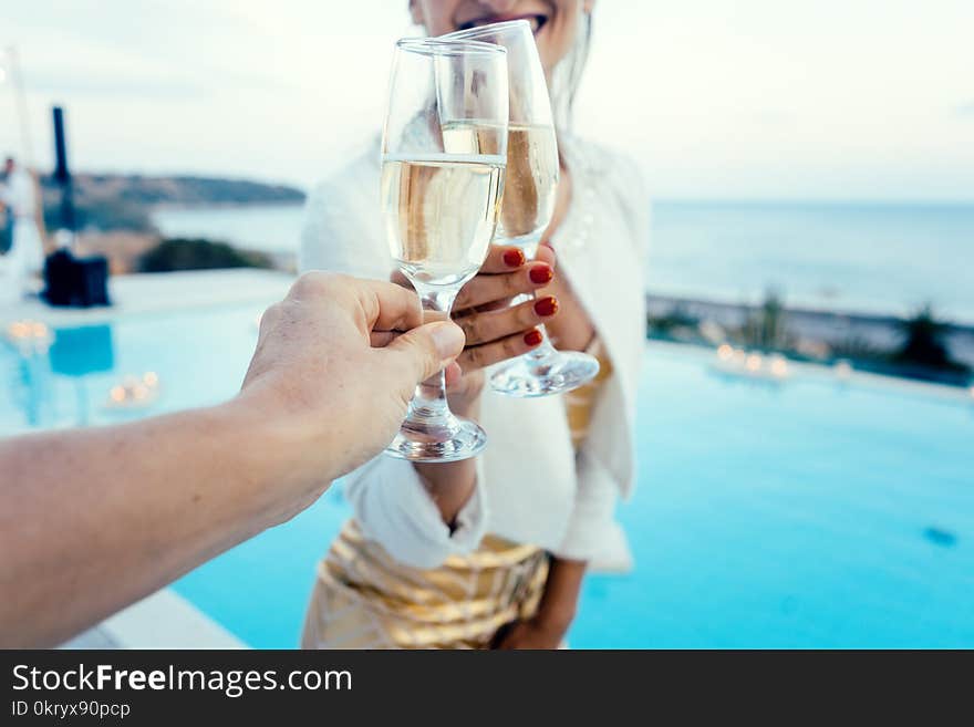 Woman and man clinking glasses at elegant pool party in summer. Woman and man clinking glasses at elegant pool party in summer