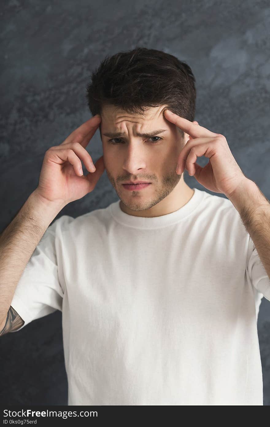 Young stressed man cover his face with hands