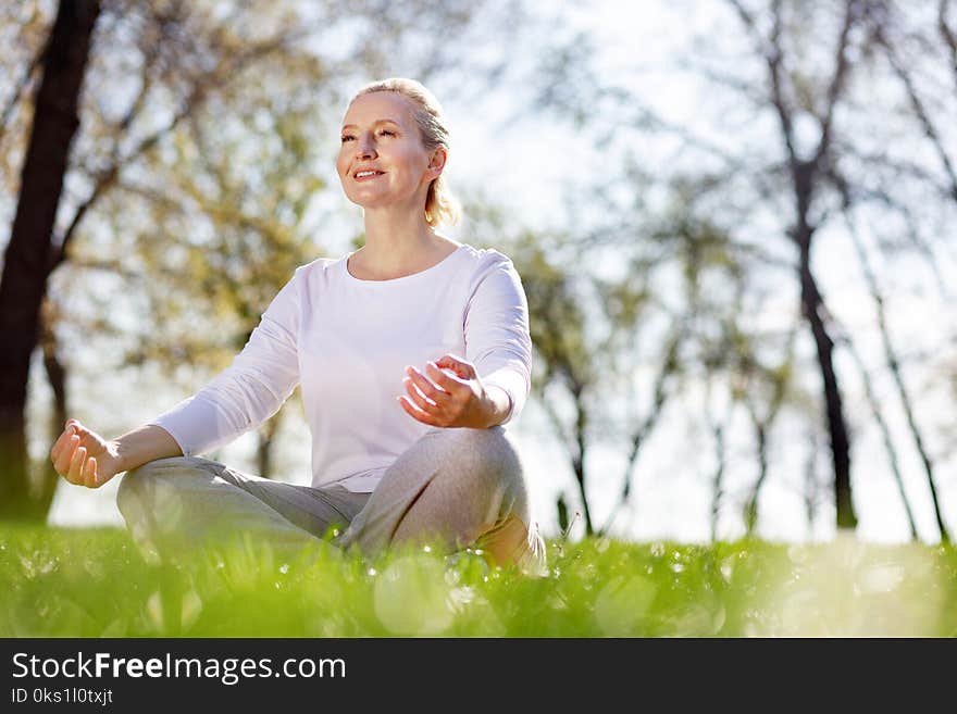 Cheerful delighted woman sitting in the grass