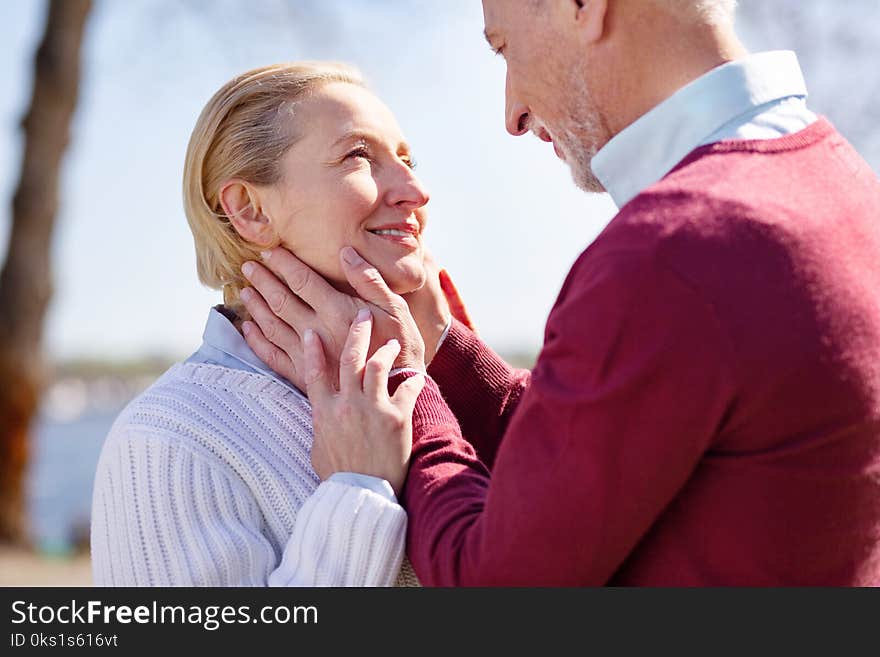 Romantic relationships. Happy nice men looking at his wifes face while being in love with her. Romantic relationships. Happy nice men looking at his wifes face while being in love with her