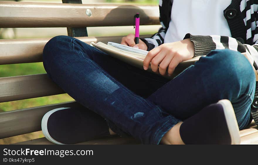 Outdoor park education. leisure time. Young cute teen sitting bench reading book.