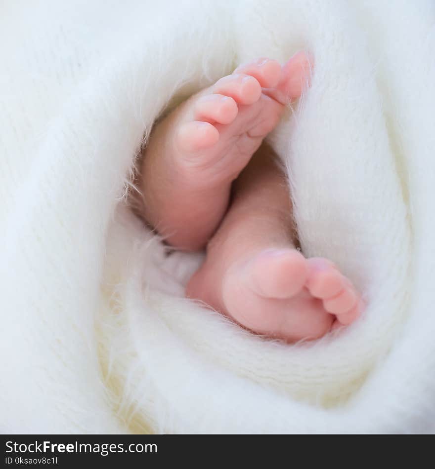 Newborn baby feet. The feet of a small child were wrapped in white cloth.