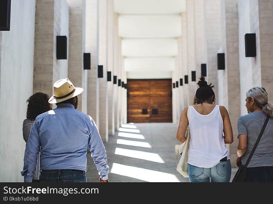 Man in Gray Long-sleeved Shirt Near White Wall