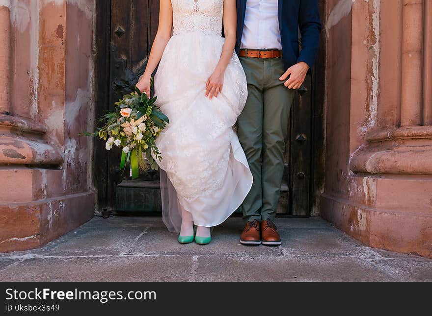 Stylish bride and groom stand door