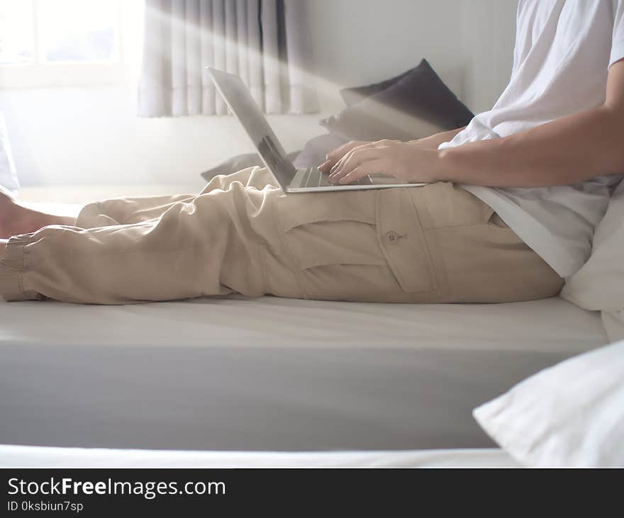 Cropped image of young man using computer laptop in living room