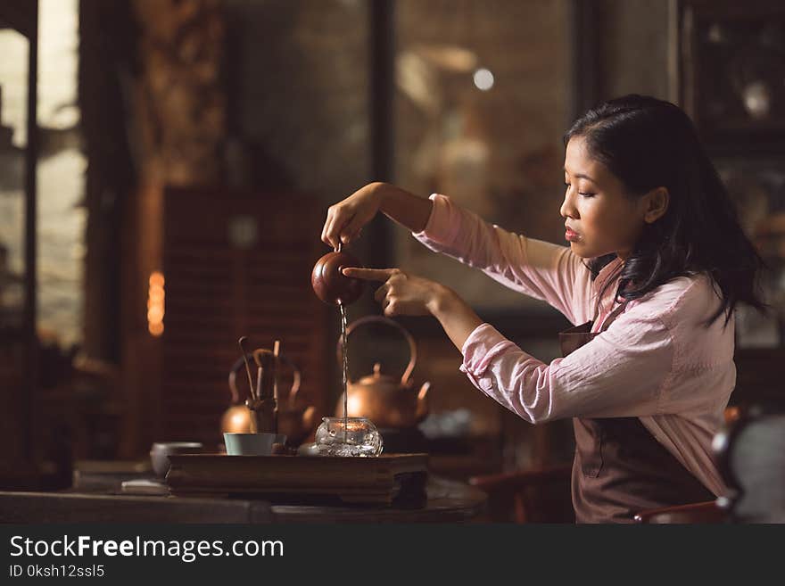 Young asian girl pouring tea in the room. Young asian girl pouring tea in the room