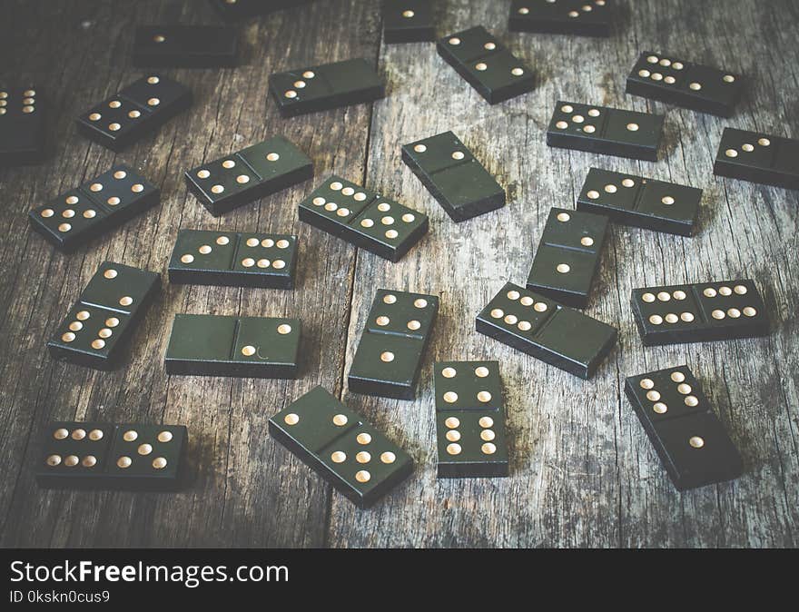 Domino pieces on the brown wooden table background soft toned