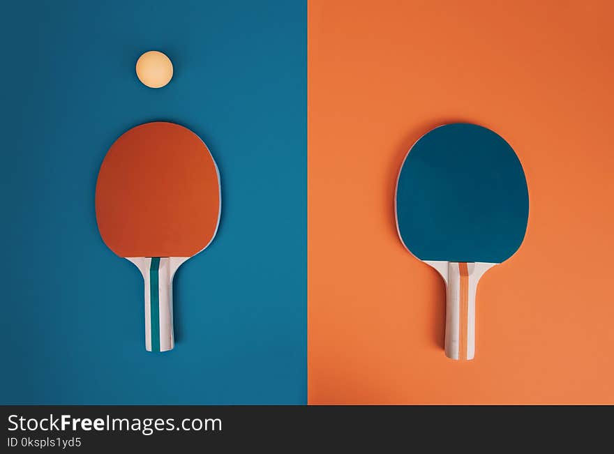 Table tennis or ping pong rackets and balls on a blue and orange table. Table tennis or ping pong rackets and balls on a blue and orange table.