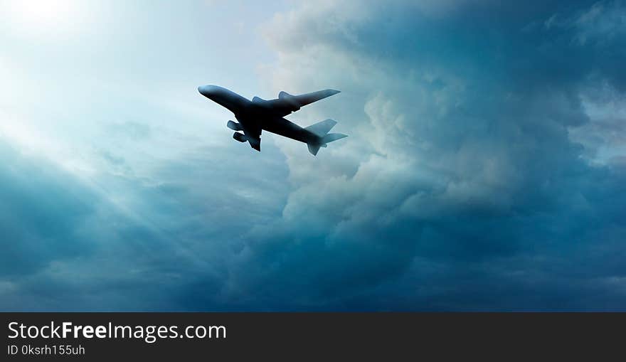 Airplane in dark blue sky with cloudy in sunrise background