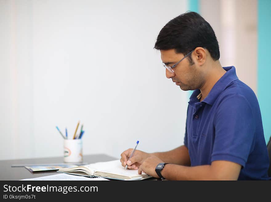 Man in Blue Polo Shirt Writing