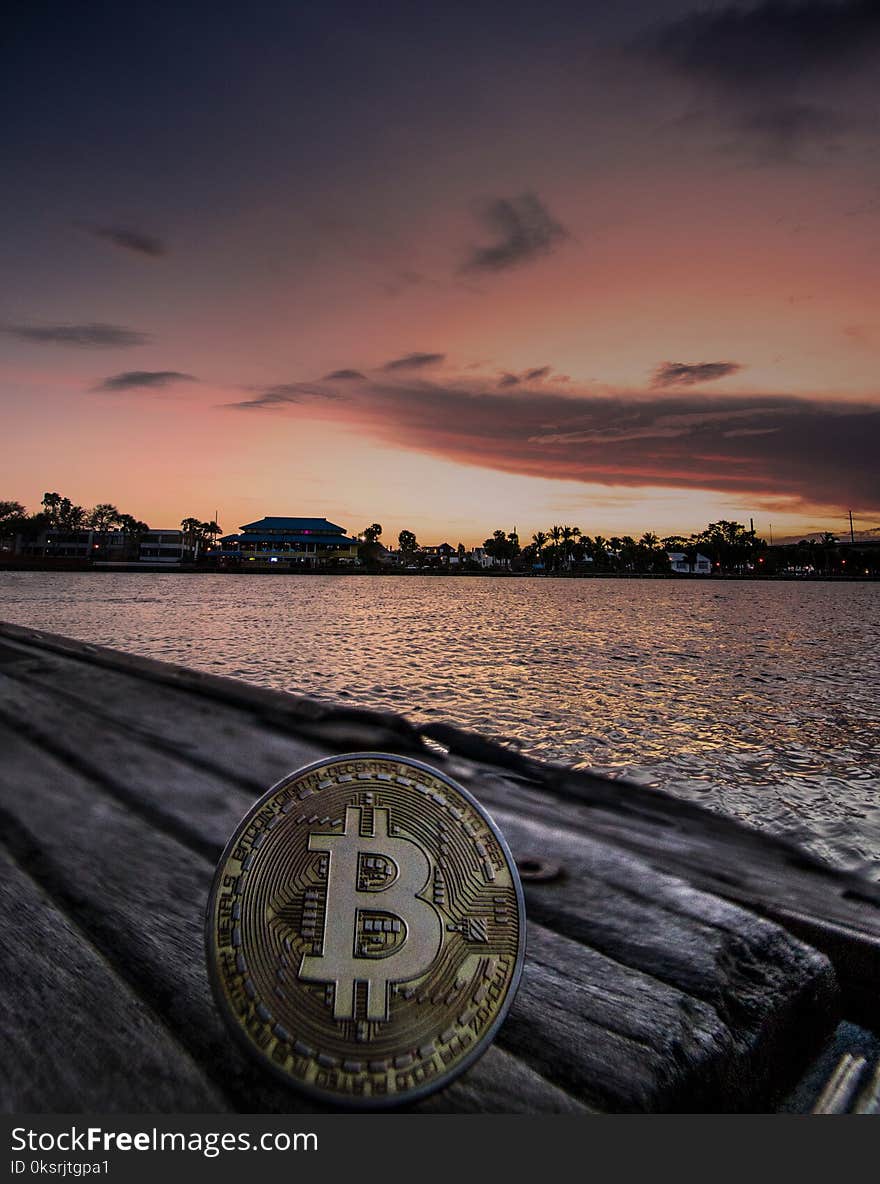 Body of Water during Dawn With Bitcoin Logo Text Overlay